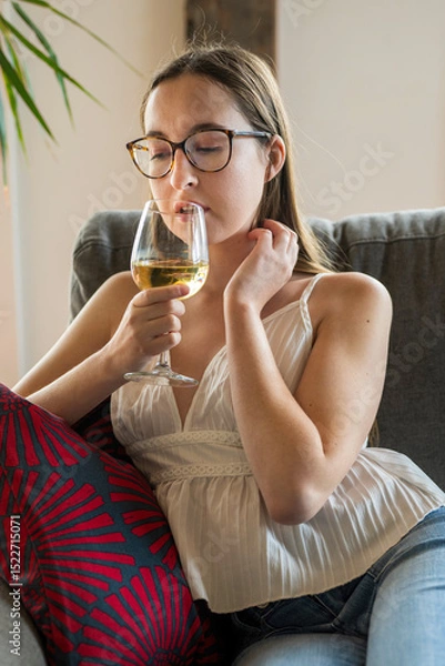 Obraz A young woman drinking wine in available light