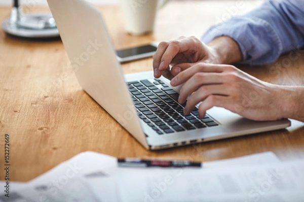Obraz businessman working on home office. Man sitting wood table and using contemporary notebook, texting message keyboard.