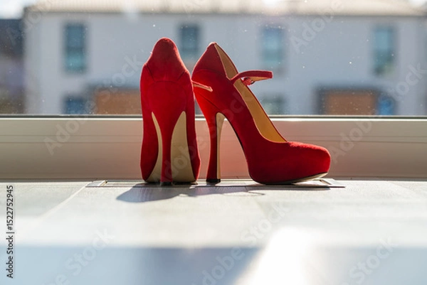 Obraz Red ladies pumps on the floor in front of a window