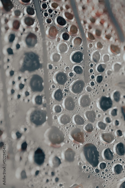 Fototapeta Water droplets gather on a surface covered in fine textures