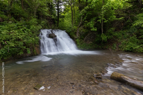 Obraz Waterfall in the mountains, river rapids, fast flow, Scenic view of pristine Carpathian nature with crystal clear water cascading over mossy rocks. Photo wallpaper, beauty of nature and the Earth.