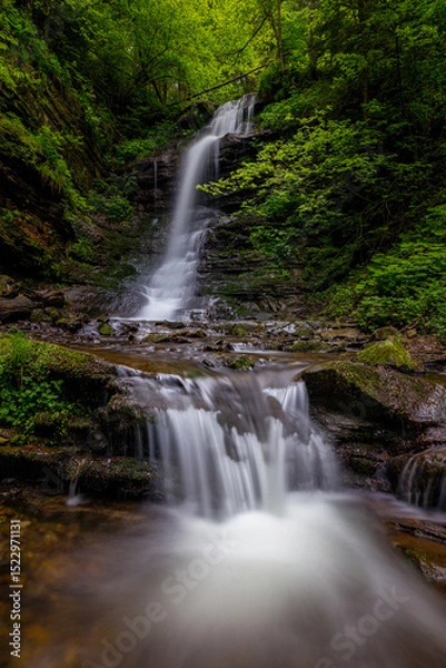 Obraz Waterfall in the mountains, river rapids, fast flow, Scenic view of pristine Carpathian nature with crystal clear water cascading over mossy rocks. Photo wallpaper, beauty of nature and the Earth.