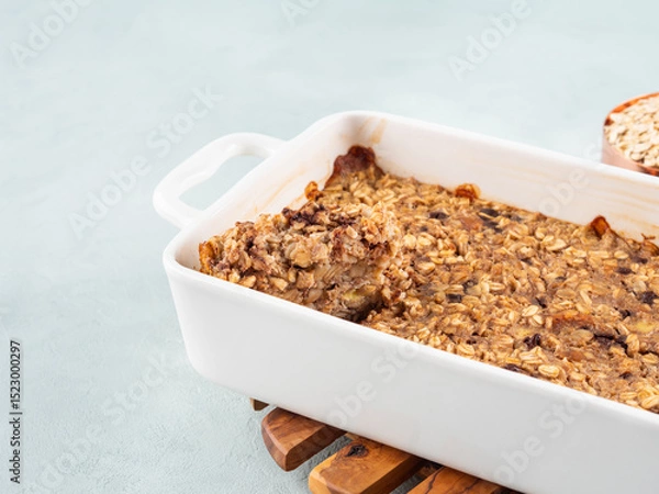 Fototapeta Vegan oatmeal banana cake in white baking pan on turquoise
