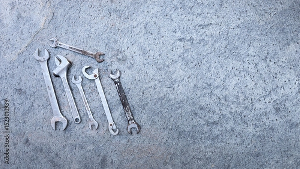 Obraz Professional tools and wrenches scattered on concrete surface, preparing for automotive repair. Copy space