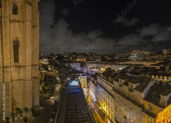 Obraz Night panoramic view of the bright Alfama district in Lisbon with a fragment of the walls of the Carmelite Monastery
