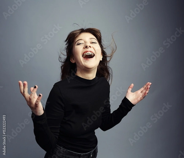 Fototapeta Exuberant Young Woman Laughing with Joy and Open Hands