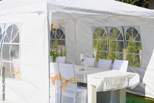 Fototapeta Garden tent for a communion party with a table and white decorations.