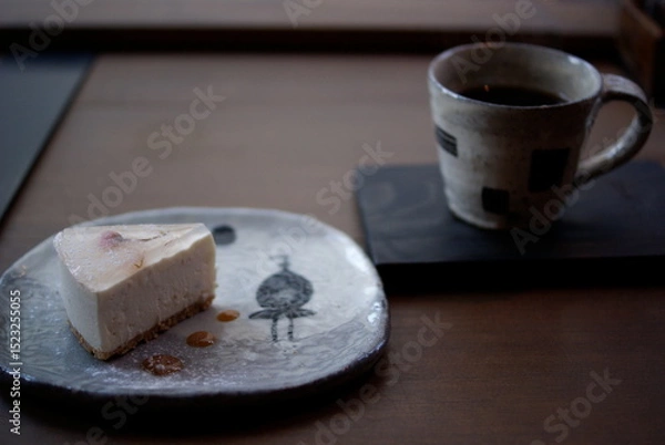 Obraz 和柄の陶器皿に載ったチーズケーキと窓辺のコーヒーセット

