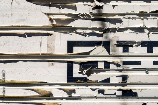 Obraz White paper peeling off and damaged by time on a stainless steel wall sheet .