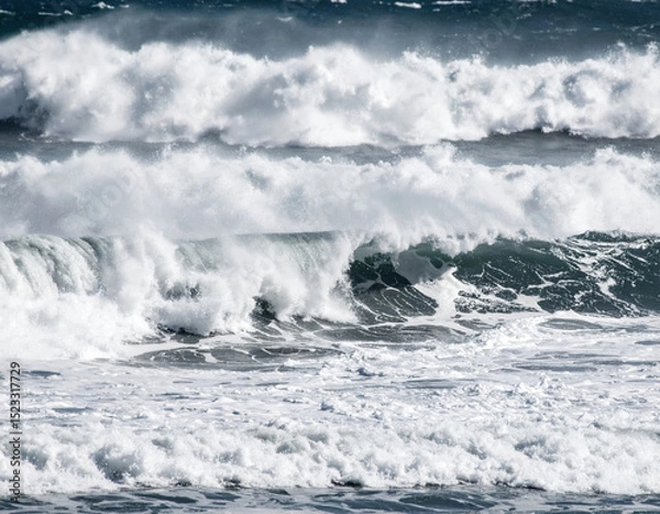 Fototapeta Powerful ocean waves crash against shore, creating stunning display of white foam and rhythmic motion. scene captures beauty and energy of nature force