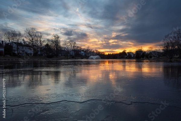 Obraz Stunning sunset reflections, on a partially frozen suburban pond