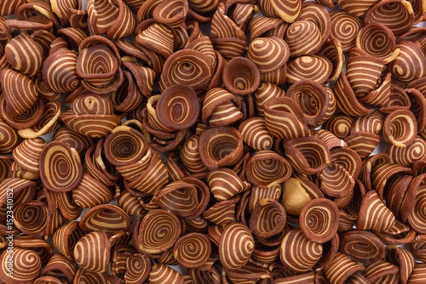 Fototapeta A top-down full frame view of numerous "Kuping Gajah" Indonesian traditional cookies. These crispy, thin cookies are characterized by their distinctive spiral pattern of light and dark brown.