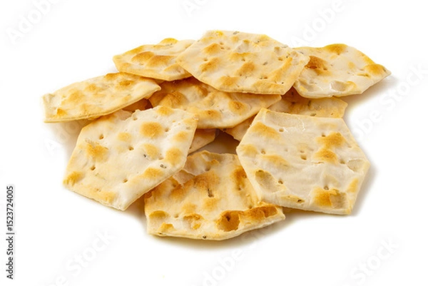 Fototapeta Stack of hexagon-shaped flatbread crackers on white background – crunchy baked snack, close-up image of artisan crispy bread chips