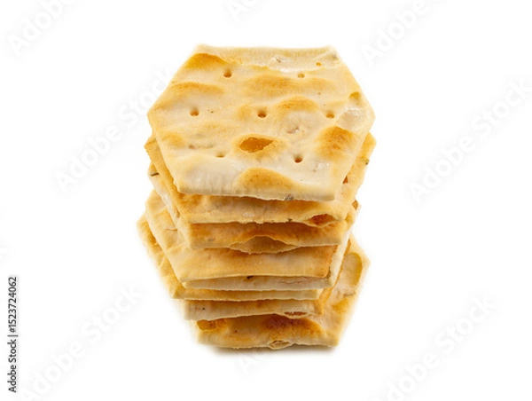 Fototapeta Stack of hexagon-shaped flatbread crackers on white background – crunchy baked snack, close-up image of artisan crispy bread chips