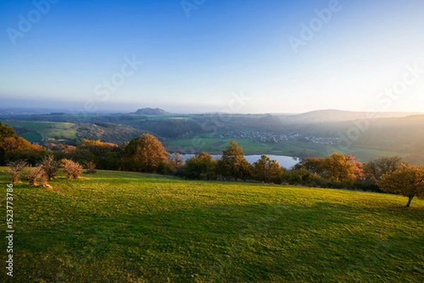 Obraz View of the landscape at the Meerfelder Maar. Nature at the crater lake in the Volcanic Eifel National Park. The surrounding area near Meerfeld at sunset in the evening.

