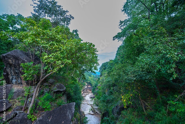 Obraz The beautiful scenery of the river valley surrounded by lush green forest, with towering rock formations like kissing cliffs and narrow bridges connecting the cliffs. Amazing kissing cliffs on river.