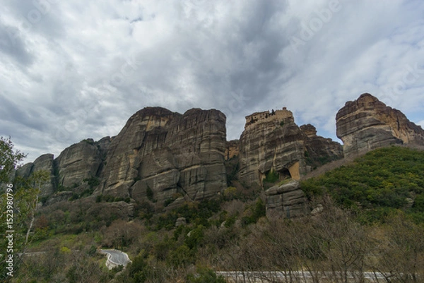 Fototapeta Scenic view of landscape of the famous and majestic rock formations of Meteora with Varlaam Monastery under a cloudy sky, Kalambaka, Thessaly, Greece