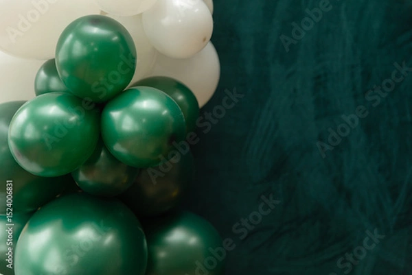 Fototapeta Elegant green and dark green balloons on a textured dark emerald green background. Perfect for celebrations, parties, or design backdrops with a luxurious feel.
