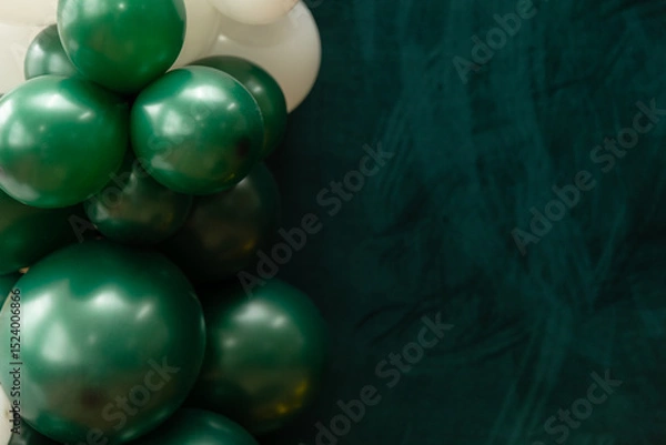 Fototapeta Elegant green and dark green balloons on a textured dark emerald green background. Perfect for celebrations, parties, or design backdrops with a luxurious feel.