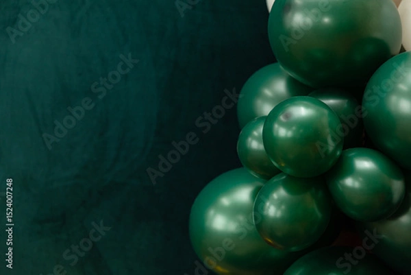 Fototapeta Elegant green and dark green balloons on a textured dark emerald green background. Perfect for celebrations, parties, or design backdrops with a luxurious feel.