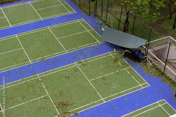 Fototapeta Damaged tennis court in Hanoi after a recent storm with debris scattered across the surface