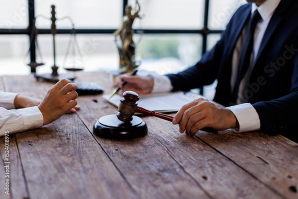 Obraz Two lawyers Consultation and conference discussing legal matters at a desk with a gavel, scales of justice law symbolizing law and justice, justice and lawyer Business partnership meeting concept. 
