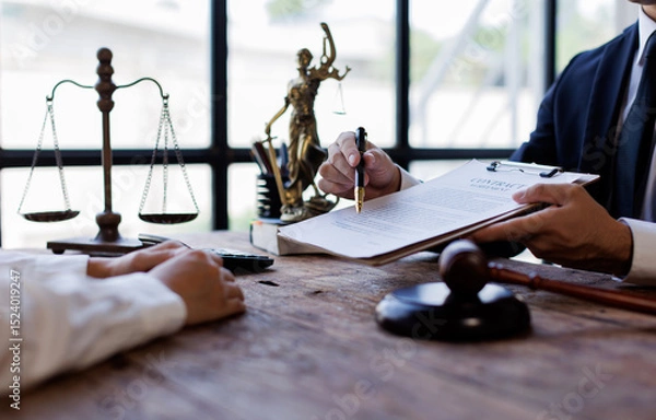 Obraz Two lawyers Consultation and conference discussing legal matters at a desk with a gavel, scales of justice law symbolizing law and justice, justice and lawyer Business partnership meeting concept. 
