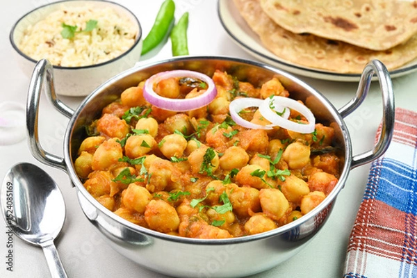 Obraz Serving chana masala dish with roti and rice.