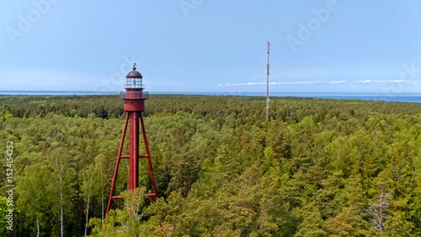 Fototapeta Ruhnu Island features a historic lighthouse amidst lush green forests and coastal views