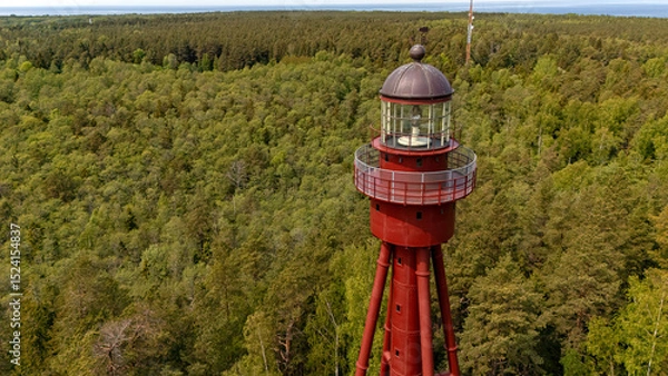Fototapeta Exploration of the historic Ruhnu lighthouse in Estonia surrounded by lush greenery