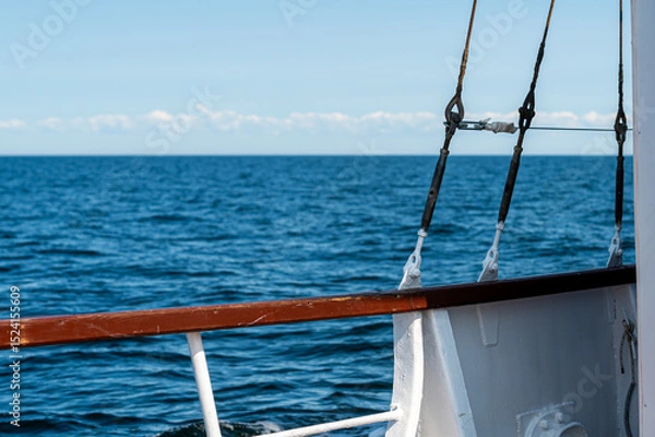 Fototapeta Sailboat deck overlooks calm ocean waters under a clear blue sky in summer