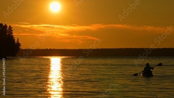 Fototapeta Woman engaging in yoga on a paddleboard at Lake Manitou during the golden hour, physical activity, mental well-being, and the serenity of nature. Tranquil waters and floating SUP board slow motion.