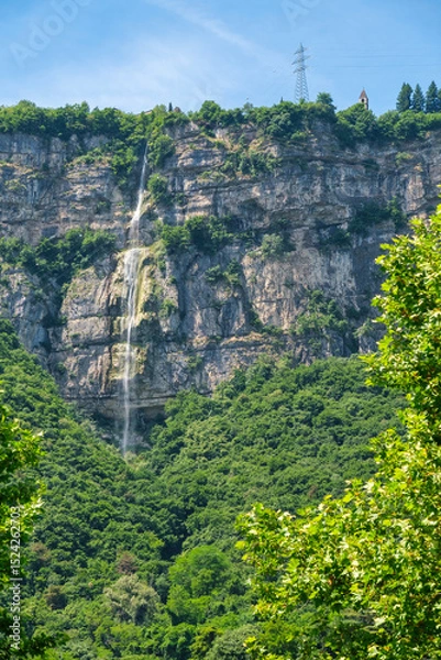 Fototapeta Vertical view of a waterfall cascading down a rocky cliff near Trento, Italy
