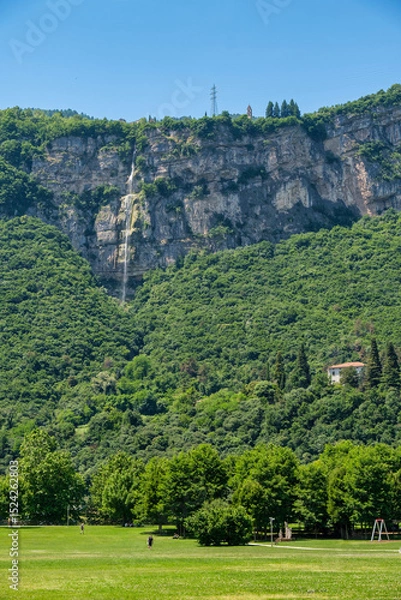 Fototapeta Vertical view of a waterfall cascading down a rocky cliff near Trento, Italy