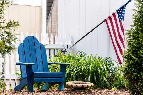 Obraz Adirondack chair and American flag in backyard 