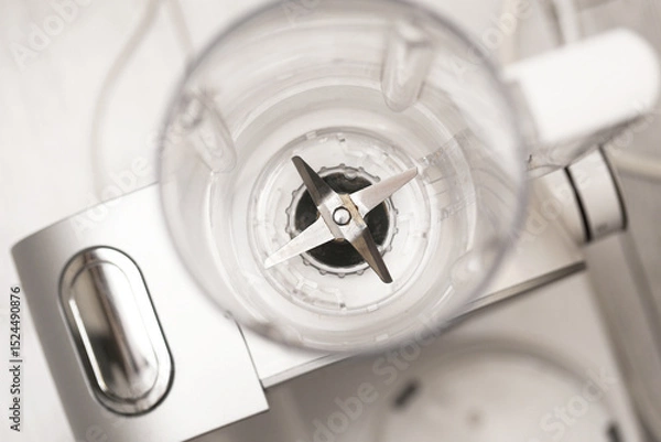 Fototapeta Top view of blender. Empty plastic jug with sharp blades. Kitchen appliance ready. Home cooking preparation. Clean white equipment. Modern culinary tool. Food processor device.