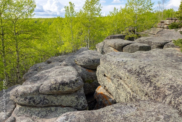 Fototapeta Huge rocks structures geological site in the place of ancient prehistoric ocean trench, nestled within a green forested environment. Rim rocks formation, Western Canada Sedimentary Basin, Alberta