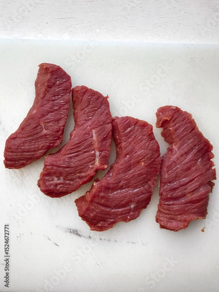 Fototapeta Raw beef steak presented on a white surface