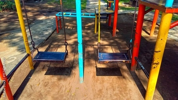 Fototapeta Vivid playground swings for children, suitable for park or school recreational areas, enhancing outdoor activity spaces.