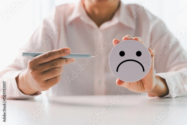 Fototapeta Close up customer hand choose sad face and blurred smiley face icon, Service rating, satisfaction concept. Negative feedback from client often reflects dissatisfaction with quality of service.