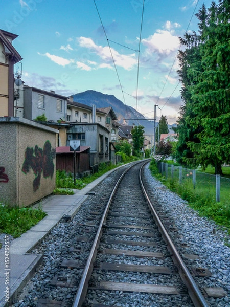 Obraz Switzerland, Meiringen, a train track traveling down train tracks near a building
