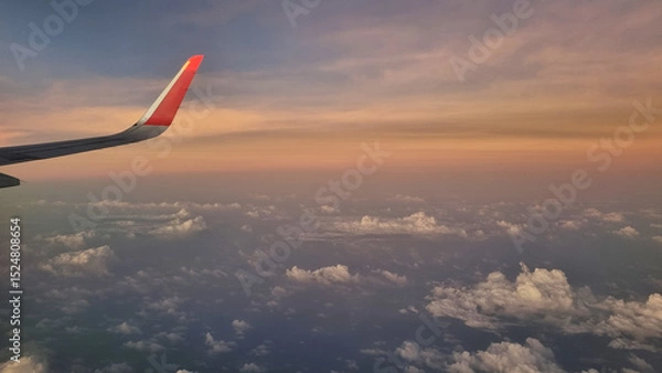 Fototapeta View From Airplane Window of Wing During Sunset. Sky Above Clouds with Vibrant Colors.