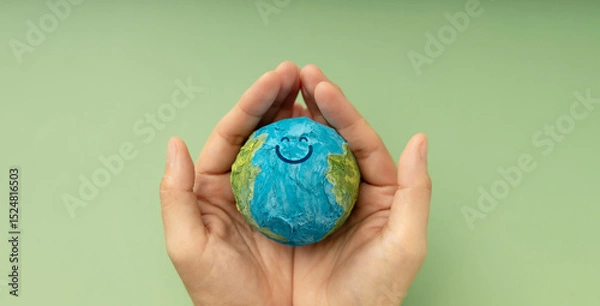 Fototapeta Happy Earth in hands symbolizing sustainability, global happiness, environmental care, and ecological responsibility, Top View