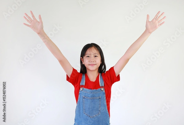 Obraz Smiling Asian girl child raised palm hands up on white studio background. Question and answer concept.