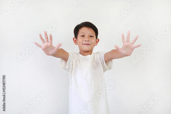 Obraz Portrait of Asian little boy kid show both five fingers or bye and looking straight camera while standing on white background. Focus at face.