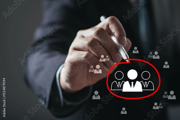 Fototapeta A hand is drawing a circle around figures, symbolizing focus on a target audience or team dynamics in a professional setting.