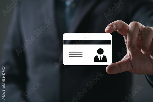 Fototapeta A person holds a blank identification card, emphasizing professionalism and identity in a dark, subdued environment.