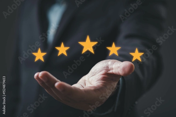 Fototapeta A hand displaying five golden stars, symbolizing excellence or high ratings in a professional context.