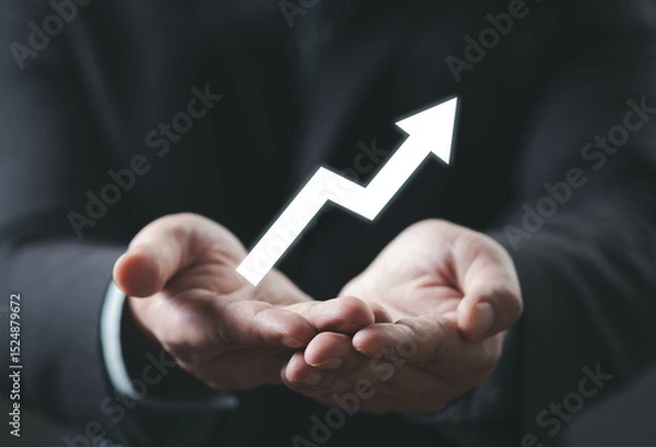 Fototapeta A pair of hands holds an upward arrow, symbolizing growth, success, or progress in a professional context.