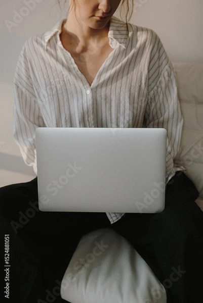 Fototapeta Casual Remote Work Scene. Relaxed Woman with Laptop in Cozy Living Space, Simple and Comfortable Style